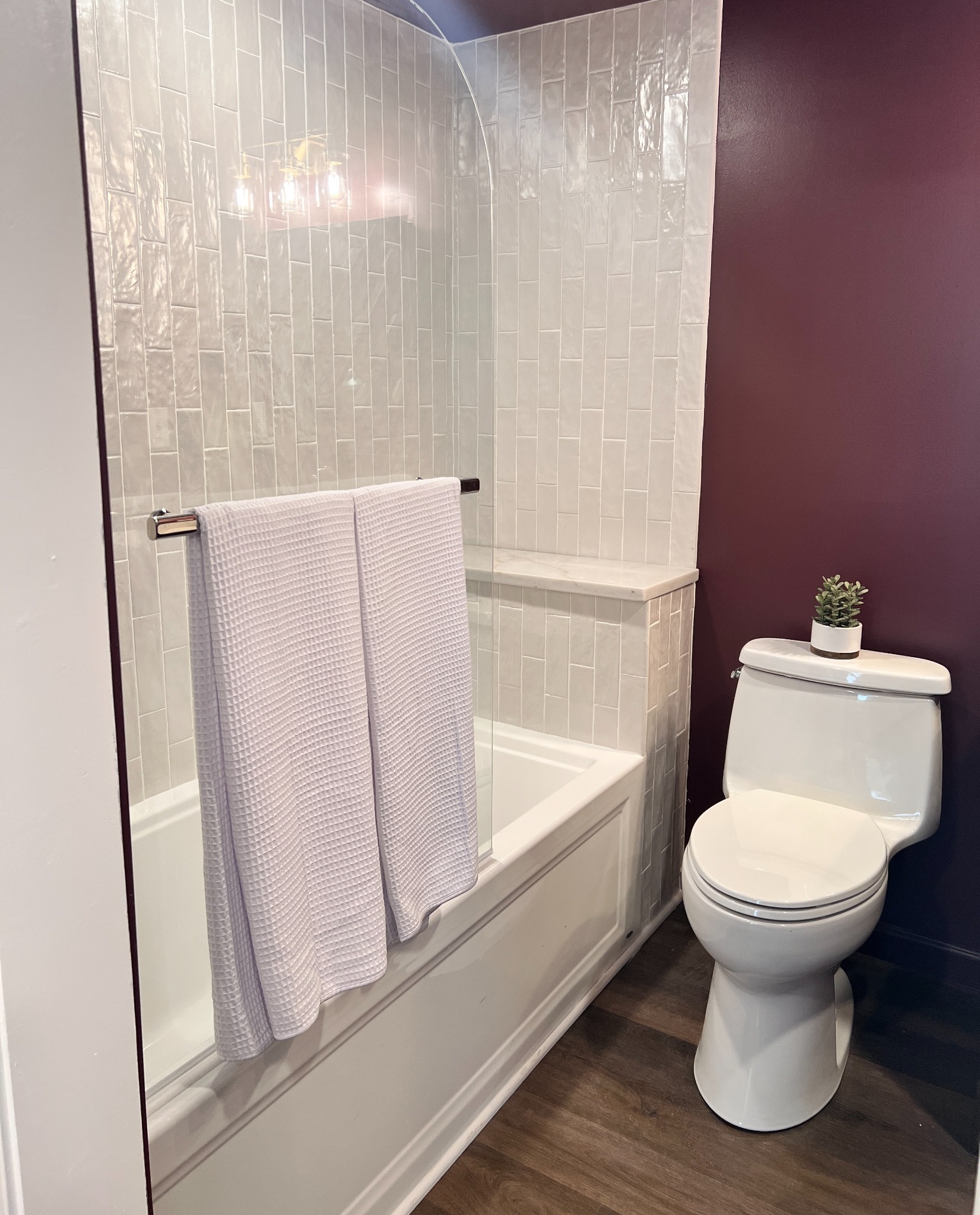 Renovated bathroom with handmade-look tile and deep plum walls