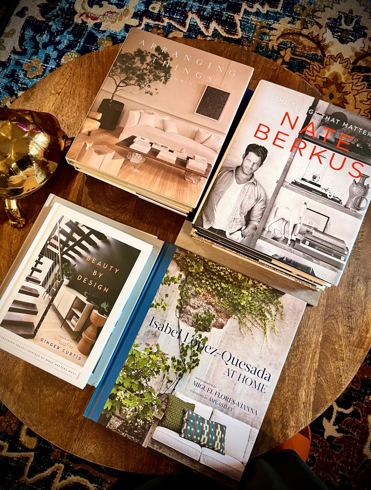 Layered coffee table vignette with books and sculptural objects